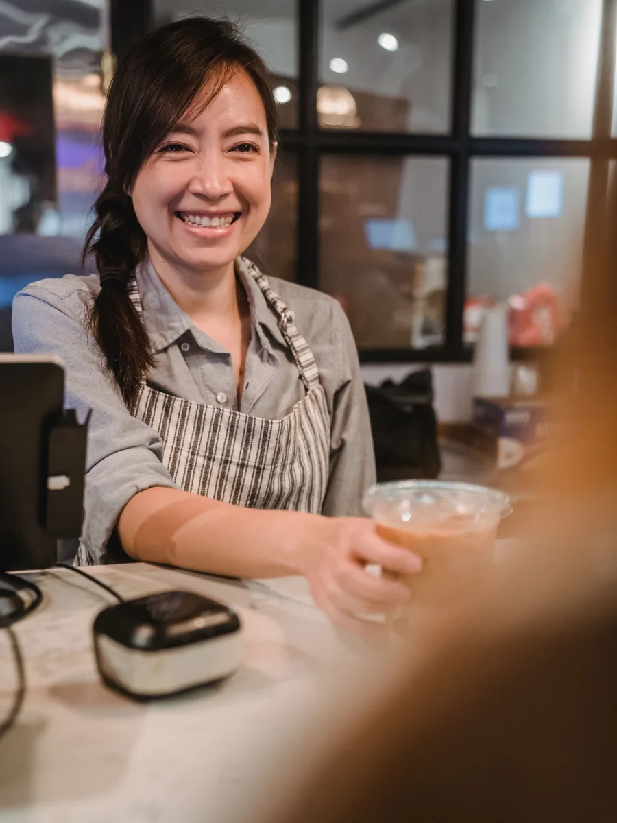 เจ้าของร้านคาเฟ่กำลังให้บริการลูกค้าที่เคาน์เตอร์
